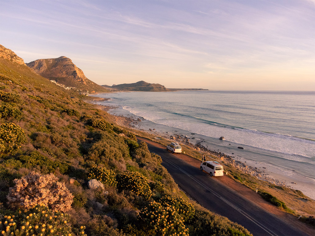 Stoked Surf Vans parked next to the road by the beach early in the morning