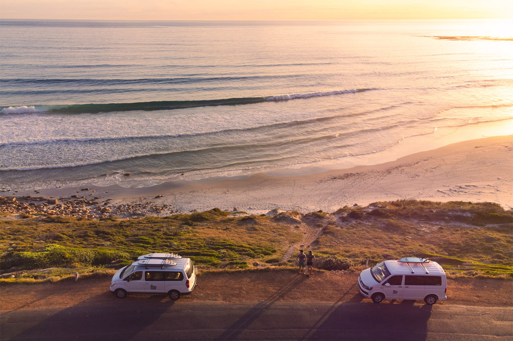 Stoked Surf team packed with their two vans on the side of the road looking out over the Cape Town oceans