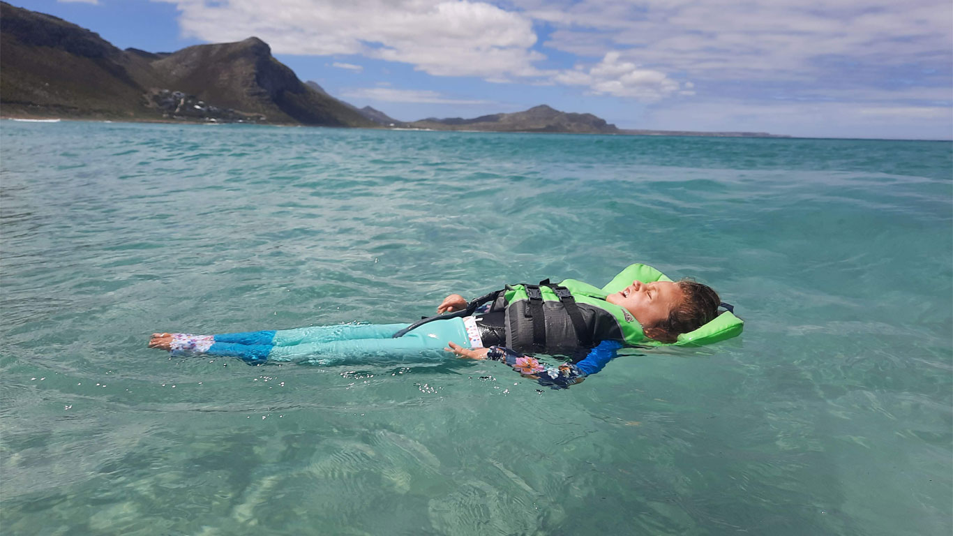 Grace floating in the ocean water with her safety gear.