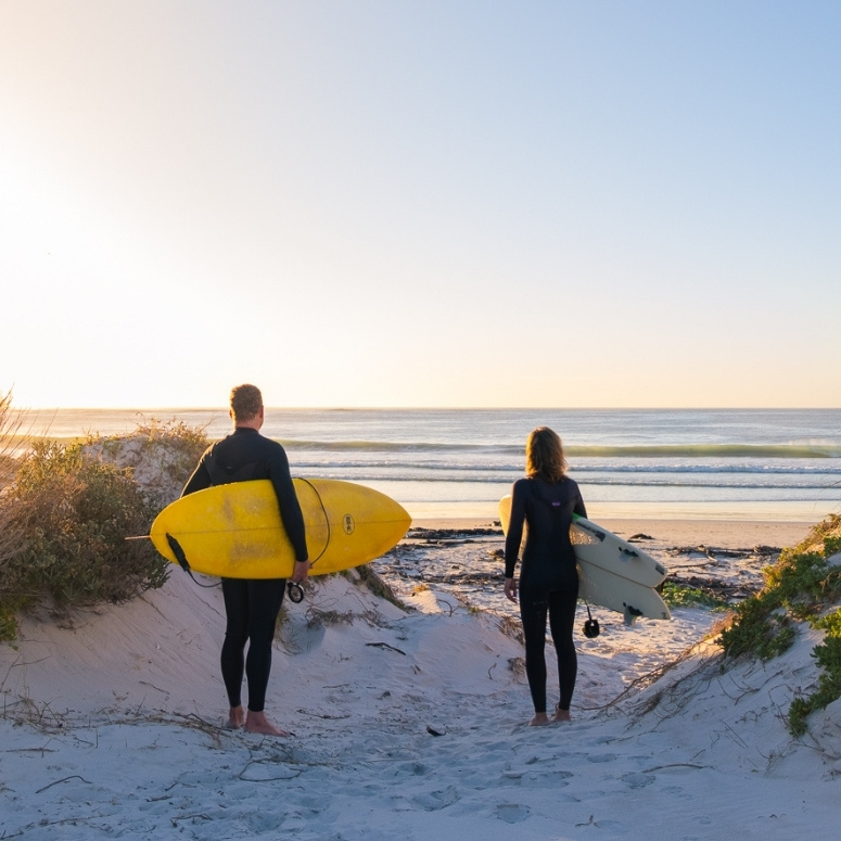 Experienced surfers heading to the beach for a guided surf session in Cape Town.