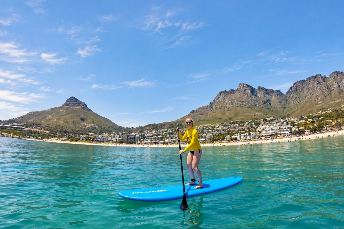 Guest stand-up paddleboarding at Camps Bay in Cape Town.