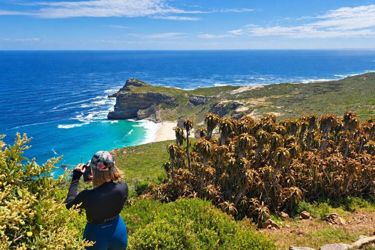 Guest photographing the view over Cape Point & Cape of Good Hope on a Stoked Surf day tour in Cape Town
